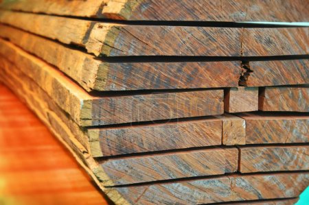Foto de Un primer plano de tablones de madera apilados uno encima del otro sobre un fondo azul y naranja - Imagen libre de derechos