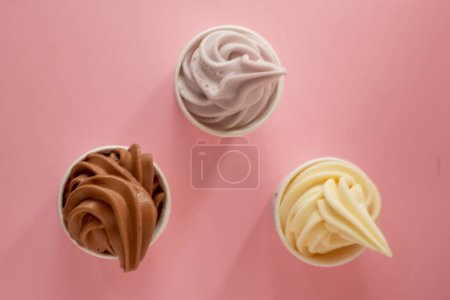 Téléchargez les photos : Une vue de dessus de chocolat, vanille et taro crème glacée de service doux sur une table rose - en image libre de droit