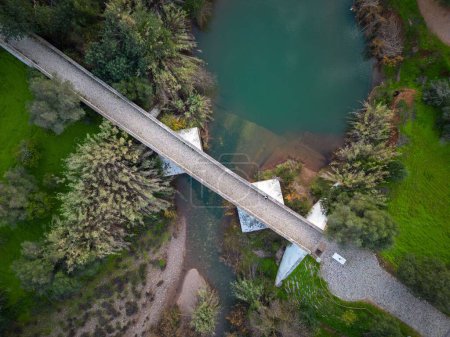 Téléchargez les photos : Vue aérienne d'une personne debout sur le pont au-dessus de la rivière entourée d'arbres - en image libre de droit