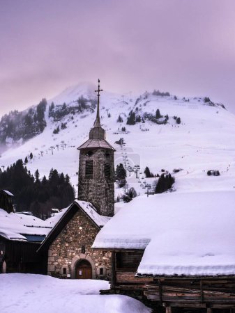 Photo for A vertical shot of the Chappelle du Chinaillon Chapel in Le Grand-Bornand, France in snowy winter - Royalty Free Image