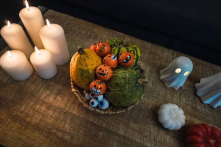 Foto de Un alto ángulo de decoraciones de Halloween de tazas, velas, figuras fantasma y calabazas puestas sobre la mesa - Imagen libre de derechos