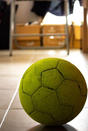 Photo for The vertical close-up view of a green ball over the tiled floor in a room - Royalty Free Image