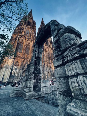 Photo for A low angle shot of the Cologne Cathedral and tourists visiting the sight - Royalty Free Image