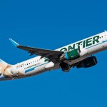 A Frontier Airlines A320 N233FR airplane flying in a blue sky
