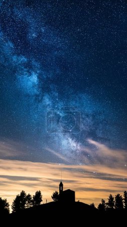 Photo for A vertical view of the silhouettes of a Sanctuary and trees under the starry night sky - Royalty Free Image