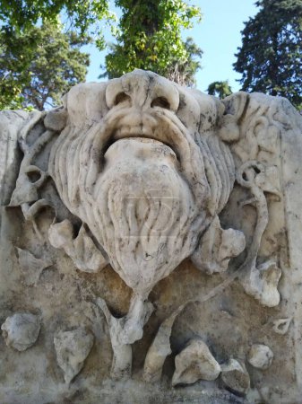 Foto de Un primer plano de una estatua de piedra del León de Aspern en Viena, Austria bajo los árboles, plano vertical - Imagen libre de derechos