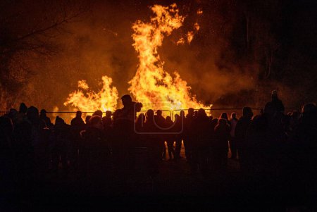 Téléchargez les photos : Les silhouettes des personnes debout devant un feu de joie lors de la table ronde annuelle Bicester feux d'artifice - en image libre de droit