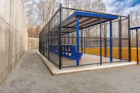 Photo for View of typical nondescript high school softball clay infield from behind the first base dugout. No people visible. Not a ticketed event. - Royalty Free Image
