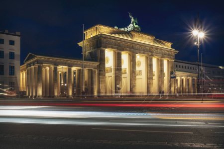 Foto de Una hermosa vista nocturna de la Puerta de Brandeburgo con una larga exposición de luces de coche i - Imagen libre de derechos