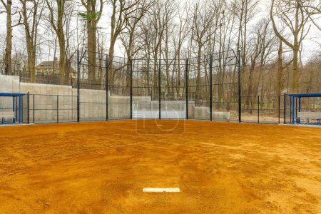 Photo for View of typical nondescript high school softball clay infield looking from pitching rubber toward home plate. No people visible. Not a ticketed event. - Royalty Free Image