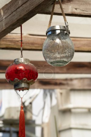 Foto de Un primer plano de bolas de vidrio solar rojo y blanco colgando del fondo de madera - Imagen libre de derechos
