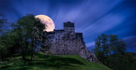 Foto de La luna detrás del castillo Castillo de Bran. Salvado, Brasov, Transilvania - Imagen libre de derechos