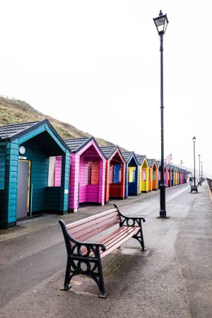 Téléchargez les photos : Un plan vertical de cabanes de plage en bois colorées à la ville balnéaire de Saltburn-by-the-Sea par une journée brumeuse, Yorkshire du Nord - en image libre de droit