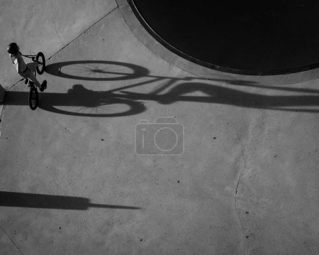 Foto de Una toma aérea en escala de grises del motorista de TX en el skate park proyectando una larga sombra - Imagen libre de derechos