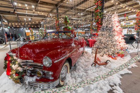 Téléchargez les photos : Une voiture rouge classique avec de la fausse neige et des décorations de Noël dans un musée - en image libre de droit