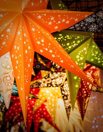 Photo for A vertical view of colorful stars shining while hung in a Christmas market - Royalty Free Image