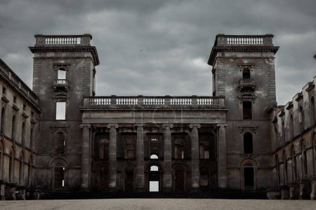 Photo for A horizontal view of the Witley Court old and dark gray building with the cloudy dark sky in the background - Royalty Free Image
