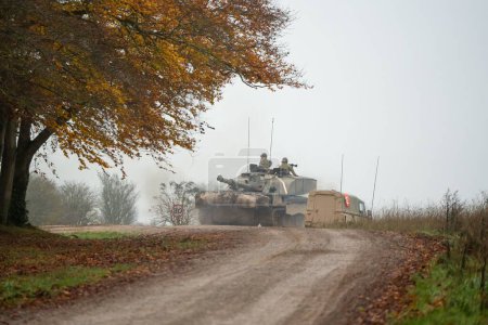 Téléchargez les photos : Un char militaire et des soldats armés sur un champ - en image libre de droit