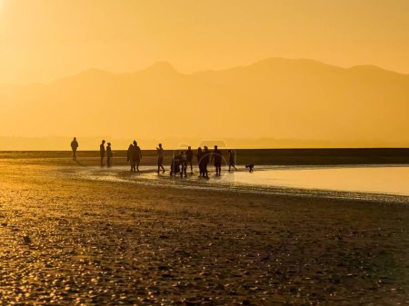 Foto de Gente en la playa de arena al atardecer en Nelson, Nueva Zelanda - Imagen libre de derechos