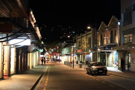 Foto de Una fascinante vista nocturna de una calle con tiendas iluminadas en Queenstown en Nueva Zelanda - Imagen libre de derechos
