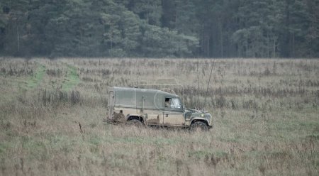 Téléchargez les photos : Un véhicule utilitaire moyen de l'armée se déplaçant dans un champ de hautes herbes lors d'un exercice militaire, Wiltshire Royaume-Uni - en image libre de droit
