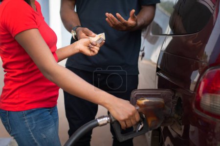 Téléchargez les photos : Chauffeur africain payant pour le carburant - en image libre de droit