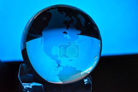 Téléchargez les photos : Une personne tenant un globus mondial, une sphère contre une lumière bleue - en image libre de droit