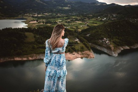 Una modelo femenina caucásica en las montañas disfrutando de la vista