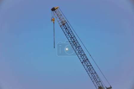 Téléchargez les photos : Une grue de construction industrielle sur fond de ciel bleu. - en image libre de droit