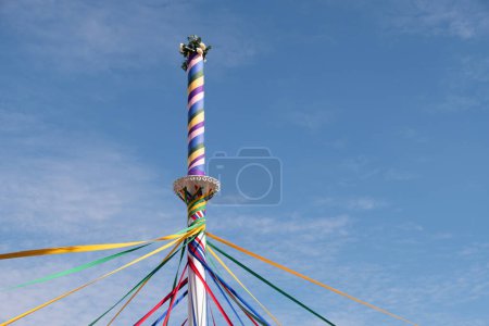 Photo for A low-angle view of colorful ribbons of a maypole woven with a blue sky in the background - Royalty Free Image
