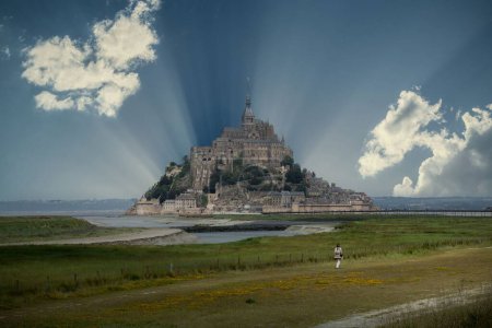 Foto de Una pintoresca vista de la isla Mont-Saint-Michel con rayos de sol detrás - Imagen libre de derechos