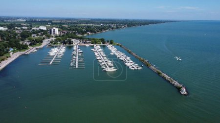 Téléchargez les photos : Vue aérienne d'un port sur la côte d'un océan rempli de bateaux, avec la ville en arrière-plan - en image libre de droit