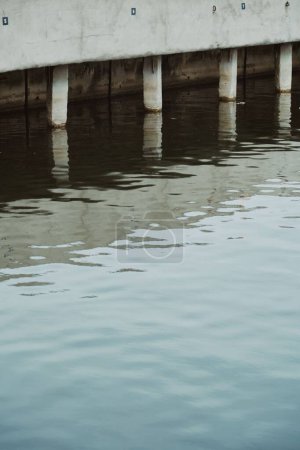 Téléchargez les photos : Un plan vertical de la base du pont reflété dans l'eau - en image libre de droit