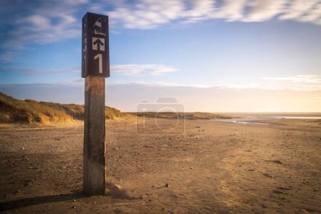 Photo for A closeup shot of a post landmark on a dried field during a bright sunny day - Royalty Free Image