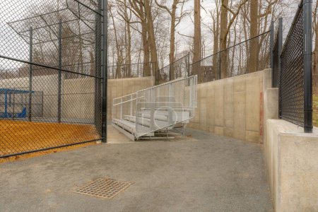 Photo for View of typical nondescript high school softball field aluminum bleachers located behind the backstop. No people visible. Not a ticketed event. - Royalty Free Image