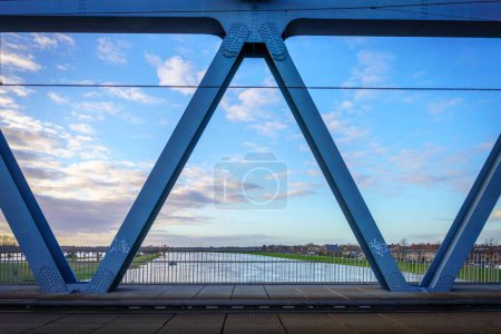 Photo for A metal structure of a bridge over a river against blue sky - Royalty Free Image