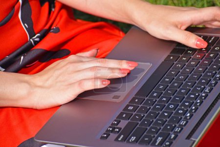 Téléchargez les photos : Un gros plan des mains de la femme en utilisant un ordinateur portable - en image libre de droit