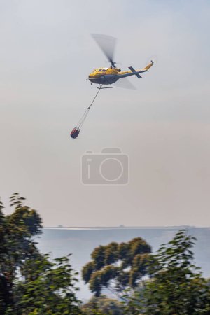 Téléchargez les photos : Un tir vertical d'un hélicoptère de lutte contre l'incendie éteint un incendie - en image libre de droit