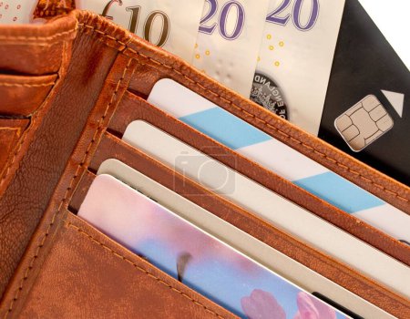 Foto de Una cartera de cuero bronceado con tarjetas bancarias, billetes de diez y veinte libras - Imagen libre de derechos