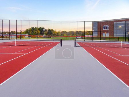 Foto de Increíble nueva pista de tenis roja con líneas blancas combinadas con líneas de pickleball gris - Imagen libre de derechos