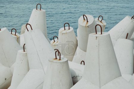Foto de Un primer plano de la pila de tetrápodos de hormigón marino blanco cerca del mar - Imagen libre de derechos