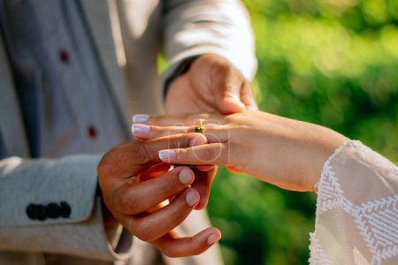 Foto de Un primer plano del proceso de usar anillos de boda al aire libre sobre un fondo aislado - Imagen libre de derechos