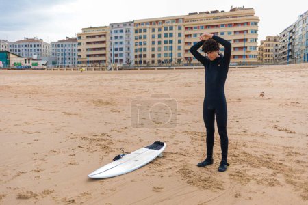 Foto de Un surfista caucásico preparándose para surfear en el océano - Imagen libre de derechos