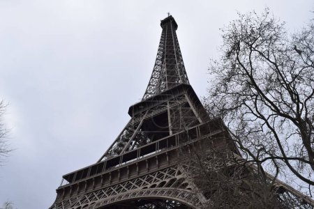 Foto de Una foto de bajo ángulo de la famosa torre Eiffel de París contra el cielo nublado durante el día - Imagen libre de derechos