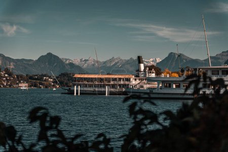 Téléchargez les photos : Un port avec des navires avec un ciel bleu nuageux et des montagnes en arrière-plan à Lucerne, Suisse - en image libre de droit