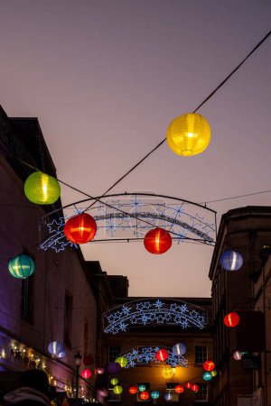Téléchargez les photos : Vue verticale à angle bas des lanternes de Noël chinoises suspendues au coucher du soleil dans les rues de Bath - en image libre de droit