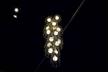 Foto de Un primer plano de ángulo bajo de una hermosa lámpara de araña con un diseño grueso sobre un fondo negro - Imagen libre de derechos