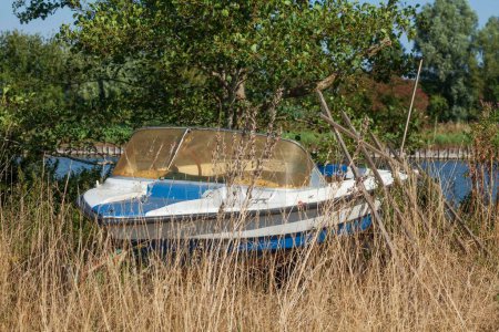Téléchargez les photos : Un vieux bateau à moteur sur un pré à Vareler Hafen, Varel, Basse-Saxe, Allemagne - en image libre de droit