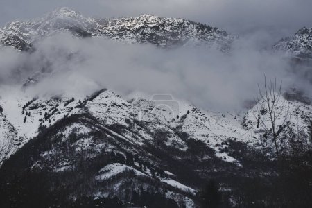 Téléchargez les photos : Un paysage de montagnes enneigées dans les nuages - en image libre de droit