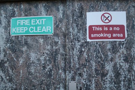 Photo for A fire exit and no smoking signage on the wall - Royalty Free Image